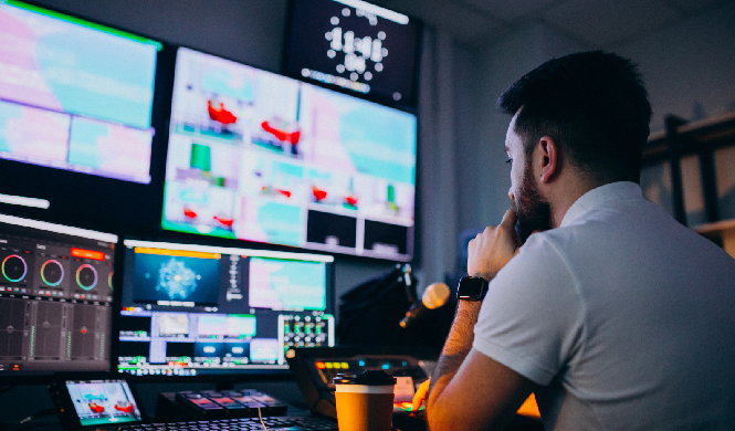 A live streaming control room with multiple monitors displaying dual streaming feeds for a hybrid event.